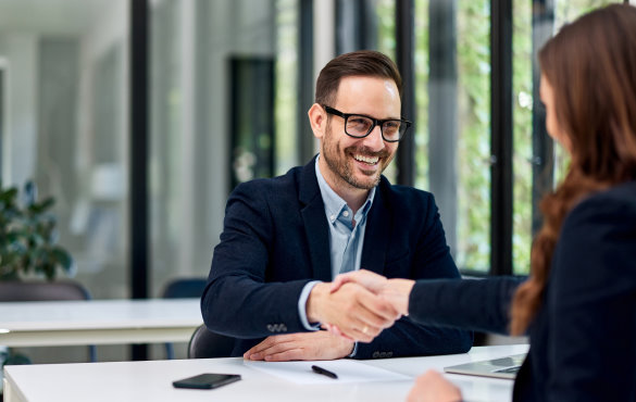 man and woman shaking hands in meeting